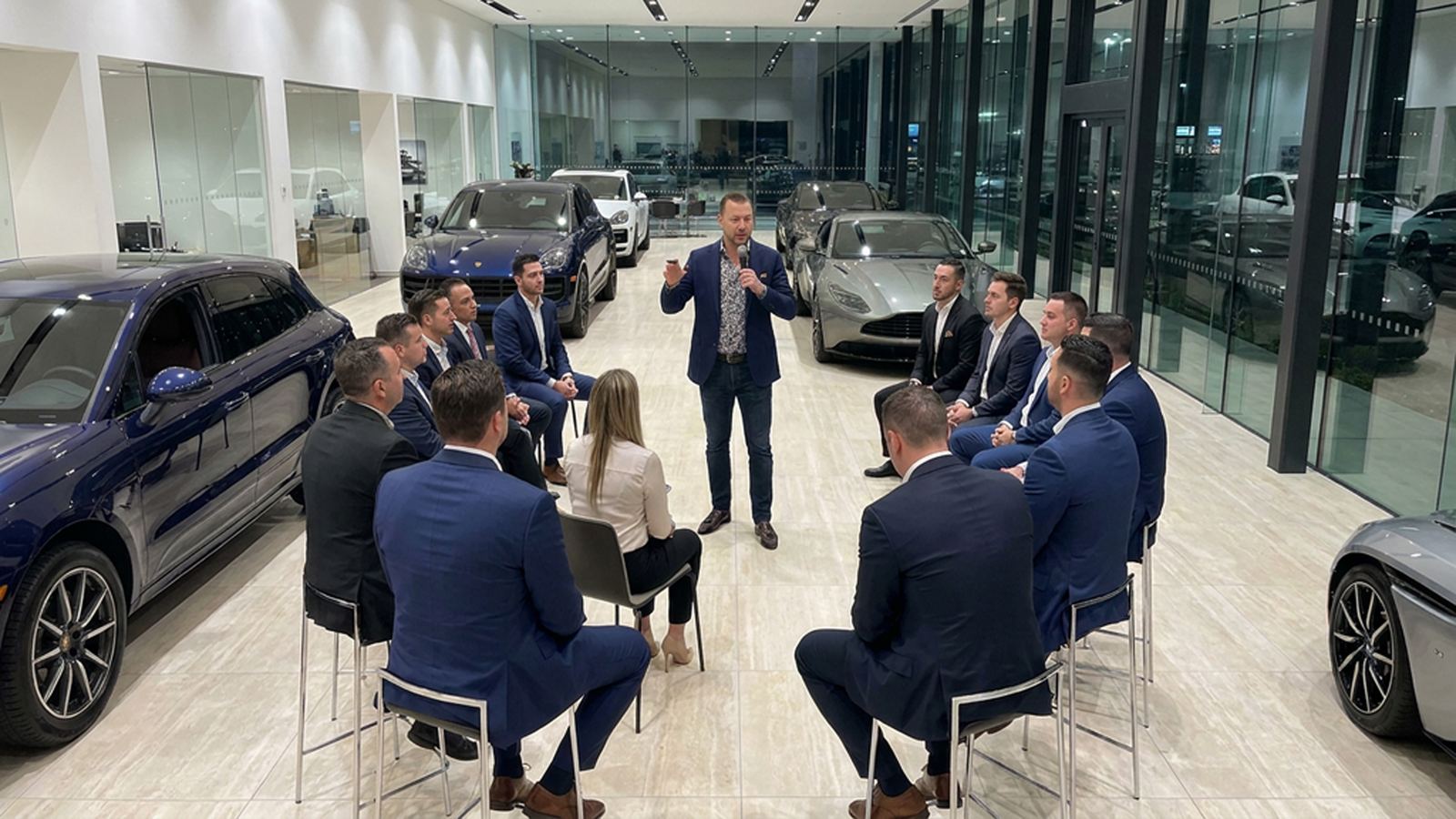Yanni Thanas leading a hands-on training session with a dealership sales team on the showroom floor